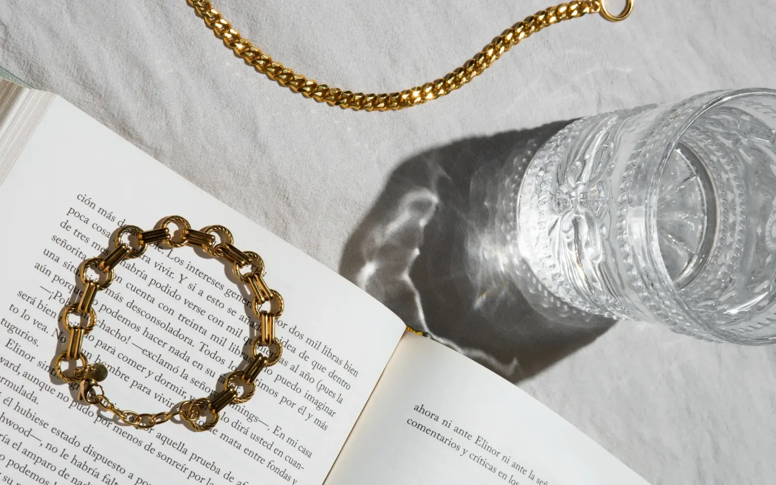 Bijou Grace gold chain and bracelet resting on an open book